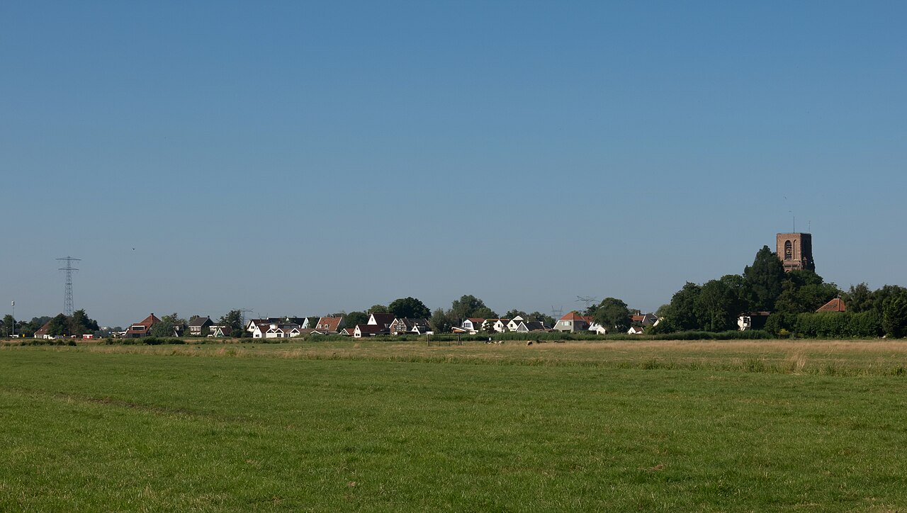 Dorpszicht van Ransdorp met de stompe kerktoren in het vlakke landschap van Waterland