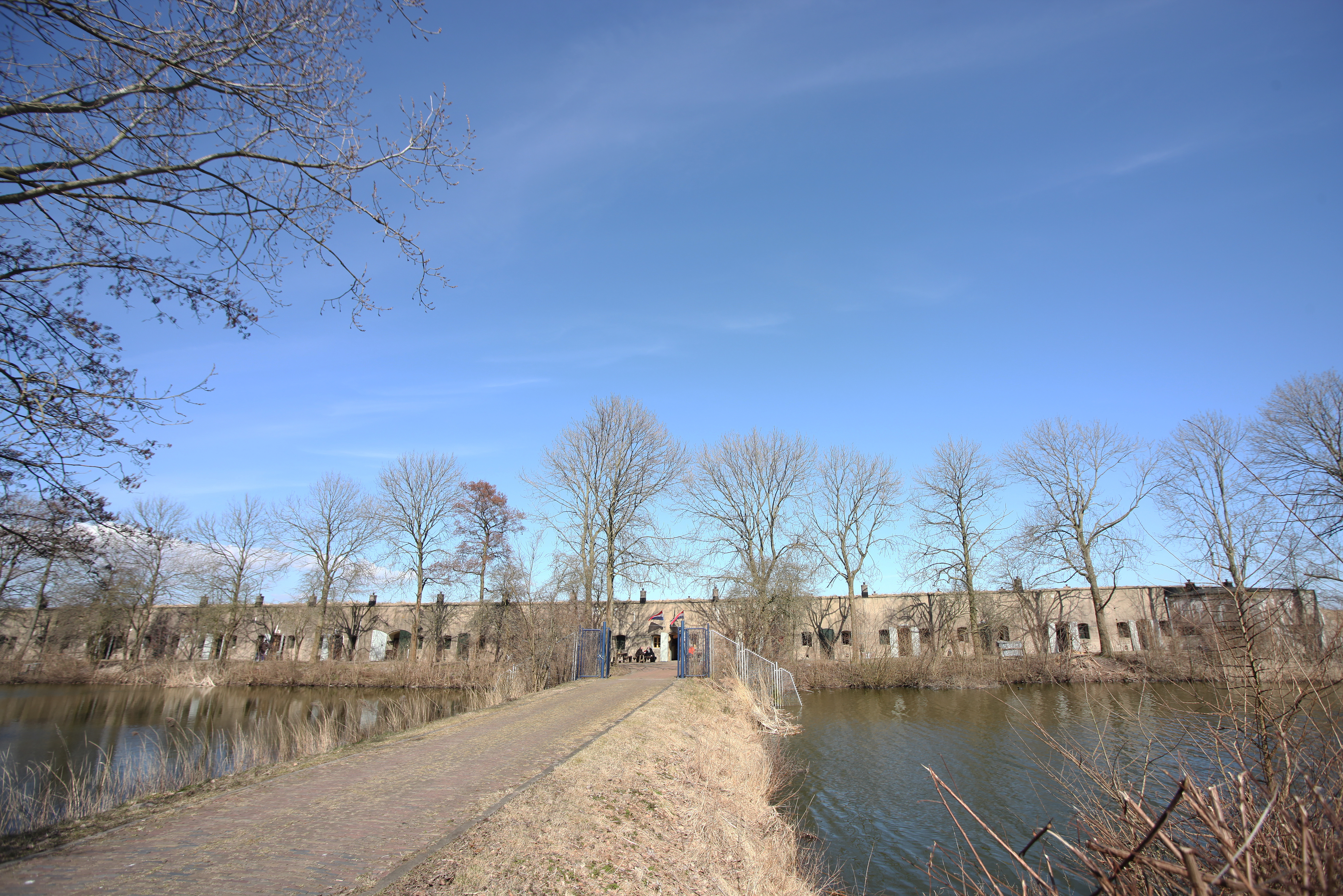 Fort bij Edam met aardgedekte gebouwen, gras en het open fortterrein.